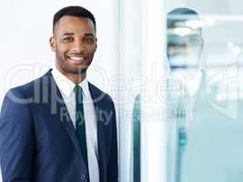 I love my job. A handsome young african american businessman standing indoors with a smile.