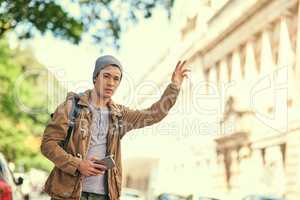 On a solo mission through the city. Cropped shot of a young man gesturing to get a cab in the city.