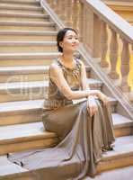 Perfect elegance. Shot of an elegantly dressed young woman sitting on a staircase.