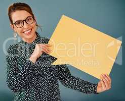 I want to share this message with you. Studio portrait of an attractive young businesswoman holding up a speech bubble while sitting against a grey background.