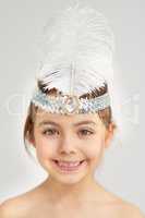 Shining bright. Studio portrait of a cute little girl wearing a sparkly feathered headband.
