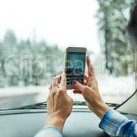 Shes fascinated with nature. Cropped shot of a passenger taking pictures while out on a road trip.