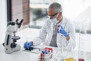 Taking note of a worthwhile test. Shot of a researcher at work on a microscope in a lab.