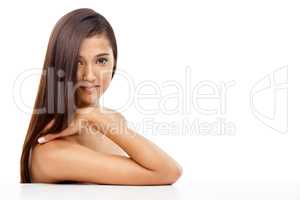 Taking care of her skin and hair. A young woman with sleek hair in studio.