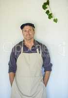 Just an ordinary day on the farm. A farmer in an apron standing in front of a wall.