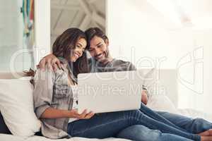 Love is sharing your wifi password. Shot of an attractive young couple spending quality time at home.