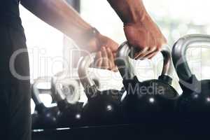 Hold on to the things that make you strong. Cropped shot of an unrecognizable sportsman lifting kettle bells in a gym.