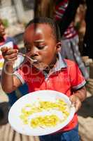 There wont be anything left on his plate once hes done. Cropped shot of children getting fed at a food outreach.