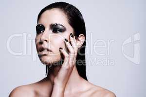 Sharp and stunning beauty. Shot of a beautiful young woman wearing metallic-colored makeup and nail polish.