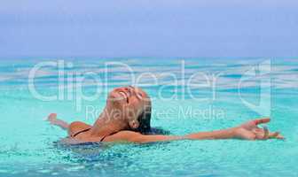 I could stay here forever.... A gorgeous young woman enjoying the water with her arms outstretched.