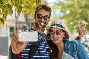 Snapping selfies in every new city. Shot of a happy tourist couple posing for a selfie while exploring a foreign city together.