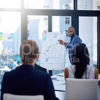 Well be upping our game with this new update. Shot of a young businessman giving a demonstration on a white board to his colleagues in a modern office.