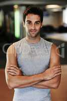 He loves hanging out at the gym. Portrait of a man wearing sports clothing standing with arms crossed at the gym.