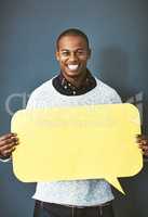 Please do share your thoughts as well. Studio portrait of a young man holding a speech bubble against a grey background.