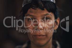 Its not dirt, its my blacksmith badge of honour. Portrait of a confident young woman working at a foundry.