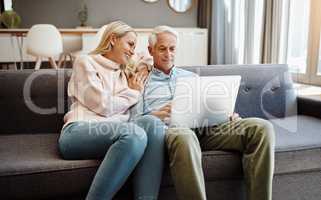 The easiest way to stay relevant. Shot of a mature couple using a laptop on the sofa at home.