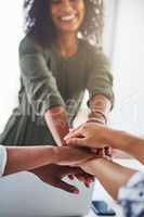 Unity in a business team is very important. Cropped shot of a group of unrecognizable businesswomen piling their hands on top of each other in the office.