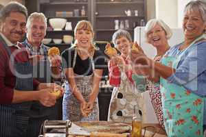 Good cooks never lack friends. Shot of a group of seniors attending a cooking class.