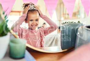Always remember that youre a princess. Shot of a little girl putting on a crown in the mirror at home.