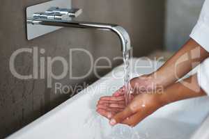 Bathroom wear thats functional and beautiful. Shot of a woman washing her hands under a tap.