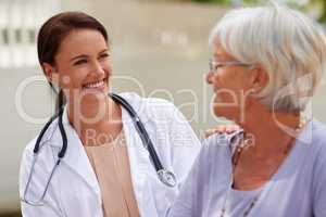 Kind and caring professional. Shot of a smiling doctor conversing with a senior patient.