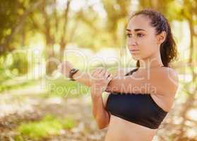 Ditch the gym and work out outdoors. Shot of a sporty young woman stretching before her run.