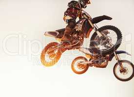 Theyre neck-a-neck. A shot of two motocross riders in midair during a race.
