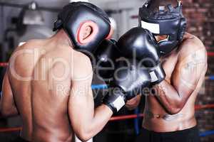 Upping each others game. Two boxers wearing protective gear sparring with one another.