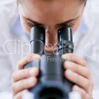 Advancing medical science. Cropped shot of a young female scientist using a microscope in a lab.