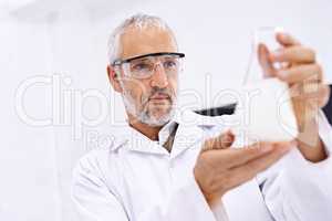 The results are conclusive. Shot of a mature male scientist examining the results of an experiment in his lab.