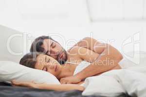 True love is being happy even when youre sleeping. Shot of a young couple sleeping comfortably in bed.