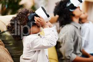 Theres a whole new world out there. Cropped shot of three little boys watching movies together through virtual reality headsets at home.