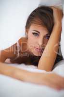 A good reason to stay in bed. Portrait of a desirable woman lying in bed under the covers.