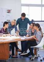 They listened intently to her solution. Cropped shot of a group of architects discussing a scale model.