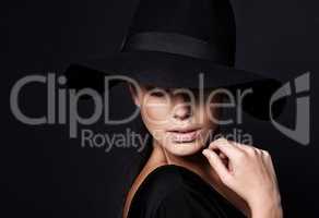 Shes a mystery youd like to unravel. Portrait of an attractive woman wearing a black hat.