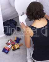 Say no to sugar. A young woman holding baked goods with her mouth covered.