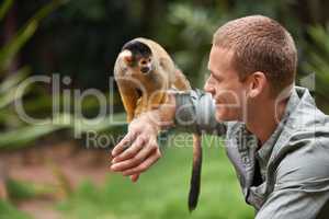 Hi there little guy. Shot of a young man interacting with a little monkey at a wildlife park.