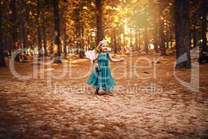 All this open space. Shot of a happy little girl holding a lamp while running around outside in the woods.