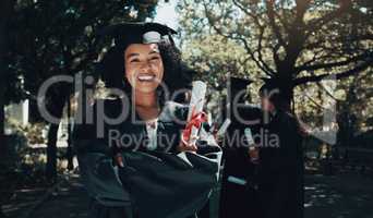 The tassel was worth the hassle. Shot of a student holding her diploma on graduation day.