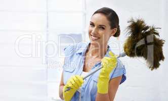 Shes dust in time. Shot of an attractive female holding a feather duster..