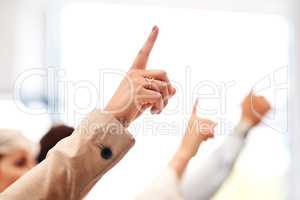 How will you make a contribution. Closeup shot of a group of unrecognisable businesspeople raising their hands.