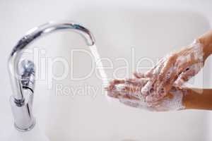 Winning the war against germs. Cropped shot of a woman washing her hands at a sink.