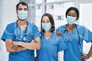 Its our aim to get you to optimum health. Portrait of a group of medical practitioners wearing face masks in a hospital.