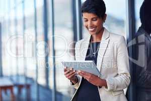 Making work more efficient and effortless with wireless technology. Shot of a young businesswoman using a digital tablet outside of an office building.