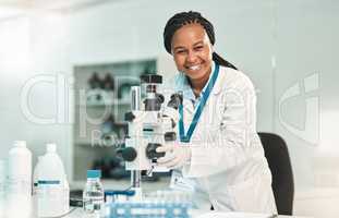 Getting a new investigation underway. Portrait of a young scientist using a microscope in a lab.