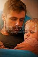 Sweet dreams, my little girl. A little girl asleep in her fathers arms in bed.