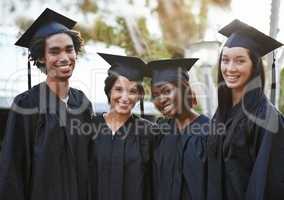 Theyve got a bright future ahead. A group of smiling college graduates standing together in cap and gown.
