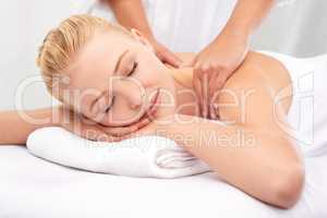 This masseuse has miracle hands.... A beautiful young woman enjoying a massage at a spa.