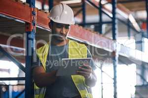 Get all the info where and when you need it. Shot of a builder using a digital tablet while working at a construction site.