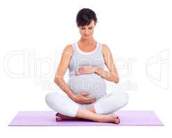 Calm and tranquility for mom and baby. A young expectant mother meditating peacefully while isolated on white.